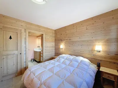 a bedroom with a large bed in a wooden wall at Chalet spacieux 5 chambres proche ski bus, vue Mont-Blanc - FR-1-560-172 in Combloux