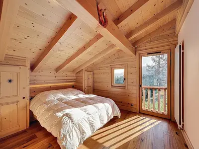 a bedroom with a bed in a log cabin at Chalet spacieux 5 chambres proche ski bus, vue Mont-Blanc - FR-1-560-172 in Combloux