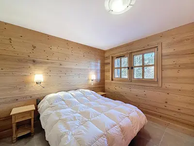 a bedroom with a bed in a wooden wall at Chalet spacieux 5 chambres proche ski bus, vue Mont-Blanc - FR-1-560-172 in Combloux