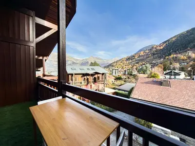 a wooden bench on the balcony of a house at Le Nid du Mont Joly, Mountain View et Parking in Saint-Gervais-les-Bains