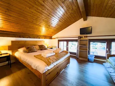 a bedroom with a large bed with a wooden ceiling at Le Nid du Mont Joly, Mountain View et Parking in Saint-Gervais-les-Bains