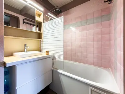 a bathroom with pink tiles and a sink and a tub at Le Nid du Mont Joly, Mountain View et Parking in Saint-Gervais-les-Bains