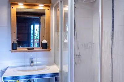 a bathroom with a sink and a shower with a mirror at 1BDR 4P apartment with balcony and parking- Megève in Megève