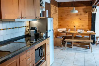 a kitchen with a table and a refrigerator and a dining room at 1BDR 4P apartment with balcony and parking- Megève in Megève