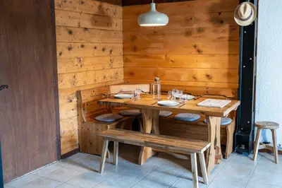 a wooden dining room with a table and benches at 1BDR 4P apartment with balcony and parking- Megève in Megève