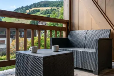 a balcony with a table and two cups on it at 1BDR 4P apartment with balcony and parking- Megève in Megève