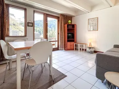 a living room with a table and chairs and a couch at Grand studio Flaine Forum vue montagne in Flaine