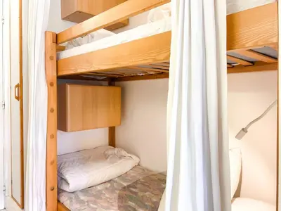 a bedroom with bunk beds with a curtain at Grand studio Flaine Forum vue montagne in Flaine