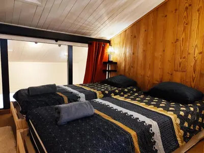 two beds in a room with wooden walls at La Kabane d'Orsin 3 étoiles in Saint-Gervais-les-Bains