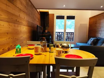 a wooden table with red plates and mugs on it at La Kabane d'Orsin 3 étoiles in Saint-Gervais-les-Bains