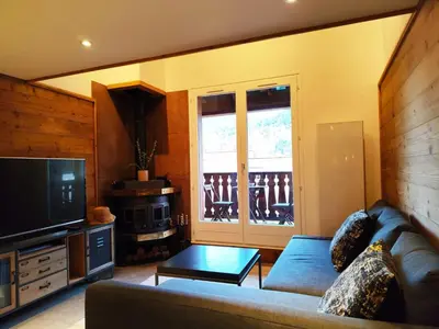 a living room with a couch and a television at La Kabane d'Orsin 3 étoiles in Saint-Gervais-les-Bains