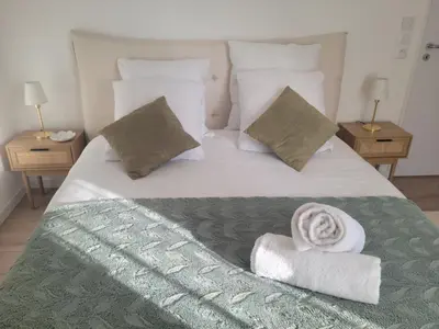 a white bed with a pile of towels on it at Alpin Les Thermes - Pres Thermes & Tramway in Saint-Gervais-les-Bains