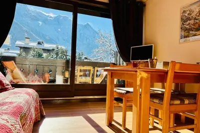 a bedroom with a desk and a view of a mountain at Bright apartment with views of Mont Blanc in Chamonix-Mont-Blanc