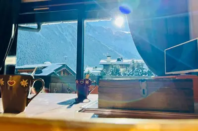 a table with a view of a mountain from a window at Bright apartment with views of Mont Blanc in Chamonix-Mont-Blanc