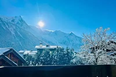 a snow covered mountain with a house in the foreground at Bright apartment with views of Mont Blanc in Chamonix-Mont-Blanc
