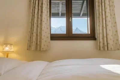 a bedroom with a bed and a window with mountains at Bright apartment with views of Mont Blanc in Chamonix-Mont-Blanc