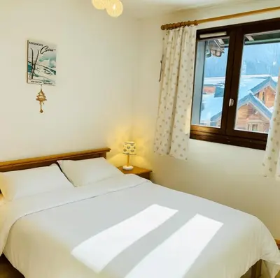 a bedroom with a white bed and a window at Bright apartment with views of Mont Blanc in Chamonix-Mont-Blanc