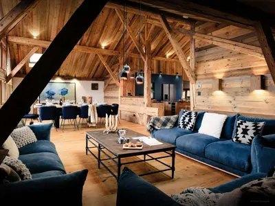 a living room with blue couches and a table at Chalet Trumont - OVO Network in Samoëns