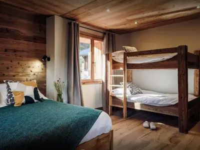 a bedroom with two bunk beds and a window at Chalet Trumont - OVO Network in Samoëns