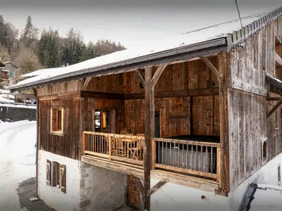a wooden building with snow on the roof at Chalet Trumont - OVO Network in Samoëns