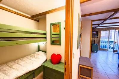 a room with two bunk beds and a red pillow at Cozy apartment in Saint-Gervais-les-Bains in Saint-Gervais-les-Bains