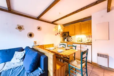 a kitchen with a couch and a table in a room at Cozy apartment in Saint-Gervais-les-Bains in Saint-Gervais-les-Bains