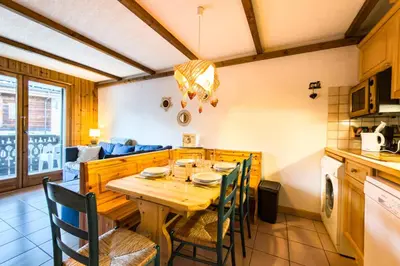 a kitchen and dining room with a wooden table and chairs at Cozy apartment in Saint-Gervais-les-Bains in Saint-Gervais-les-Bains