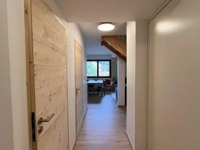 a hallway with a door leading to a dining room at Duplex neuf 78m², 2 chambres, poêle, WIFI, parking, pour 5 pers. - Arâches-la-Frasse - FR-1-836-57 in Arâches-la-Frasse