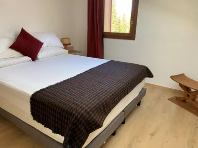 a bedroom with a bed with a plaid blanket on it at Duplex neuf 78m², 2 chambres, poêle, WIFI, parking, pour 5 pers. - Arâches-la-Frasse - FR-1-836-57 in Arâches-la-Frasse