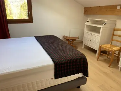 a bedroom with a bed and a desk and a chair at Duplex neuf 78m², 2 chambres, poêle, WIFI, parking, pour 5 pers. - Arâches-la-Frasse - FR-1-836-57 in Arâches-la-Frasse