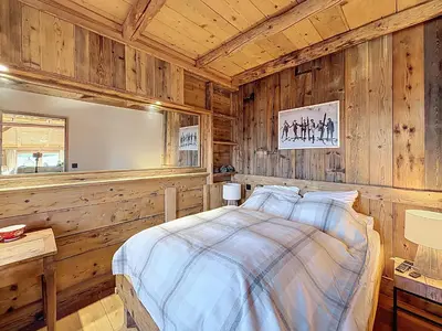 a bedroom with wooden walls and a bed in a room at Chalet 5 chambres + dortoir proche pistes Combloux - FR-1-560-173 in Combloux