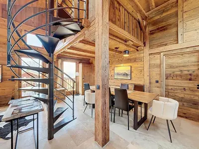 a kitchen and dining room with a spiral staircase in a log cabin at Chalet 5 chambres + dortoir proche pistes Combloux - FR-1-560-173 in Combloux