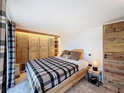 a bedroom with a bed and wooden cabinets at Chalet 5 chambres + dortoir proche pistes Combloux - FR-1-560-173 in Combloux