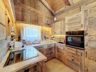 a kitchen with wooden cabinets and a stove top oven at Chalet 5 chambres + dortoir proche pistes Combloux - FR-1-560-173 in Combloux