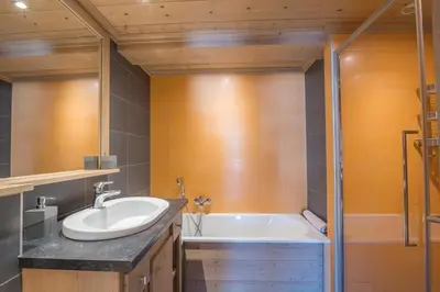 a bathroom with a sink and a bath tub at Appartement Pravy - Welkeys in Megève