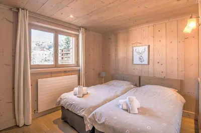 two twin beds in a room with a window at Appartement Pravy - Welkeys in Megève