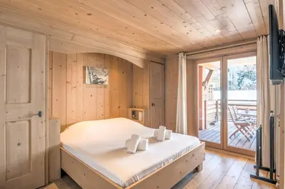 a bedroom with a bed in a room with a balcony at Appartement Pravy - Welkeys in Megève