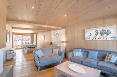 a living room with two blue couches and a table at Appartement Pravy - Welkeys in Megève