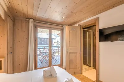 a bedroom with a bed and a large window at Appartement Pravy - Welkeys in Megève