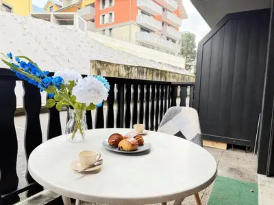 a white table with a plate of croissants and a vase of flowers at L'Orée du Parc in Saint-Gervais-les-Bains