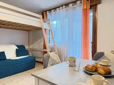 a living room with a table and a bunk bed at L'Orée du Parc in Saint-Gervais-les-Bains