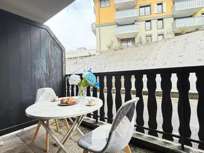a table and chairs on a balcony with a table at L'Orée du Parc in Saint-Gervais-les-Bains
