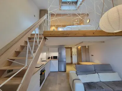 a living room with a staircase and a couch at Lechappee Valleenne in Saint-Gervais-les-Bains