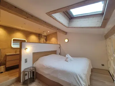 a bedroom with a large bed with a skylight at Lechappee Valleenne in Saint-Gervais-les-Bains