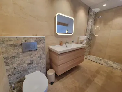 a bathroom with a sink and a toilet and a mirror at Lechappee Valleenne in Saint-Gervais-les-Bains