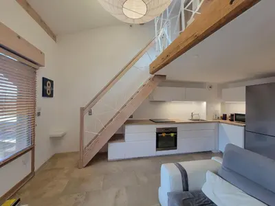 a kitchen and a living room with a staircase at Lechappee Valleenne in Saint-Gervais-les-Bains