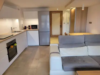 a living room with a couch and a kitchen at Lechappee Valleenne in Saint-Gervais-les-Bains