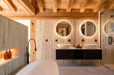 a bathroom with two sinks and two mirrors at Chalet Les Sapins - Megève in Megève