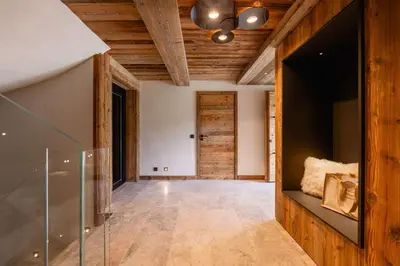 a hallway with a wooden ceiling and a glass door at Chalet Les Sapins - Megève in Megève
