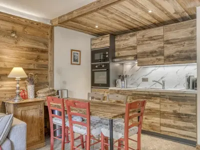 a bedroom with a large bed with a wooden headboard at Appartement rénové 1 chambre cabine, Megève, proche centre - FR-1-453-327 in Megève